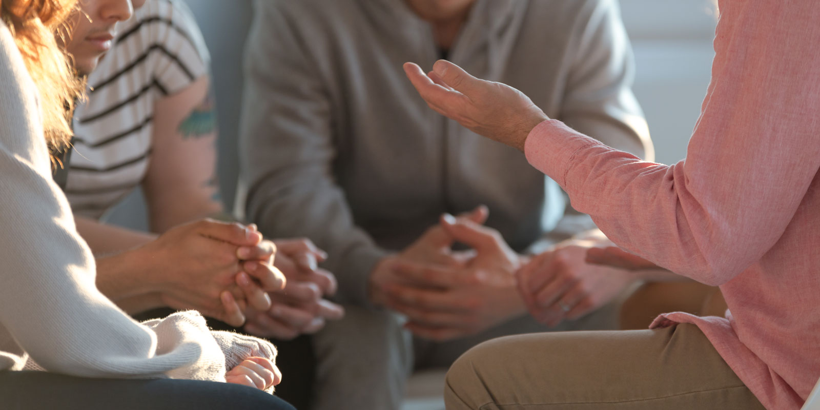 Group of people sitting in a circle and having a discussion.