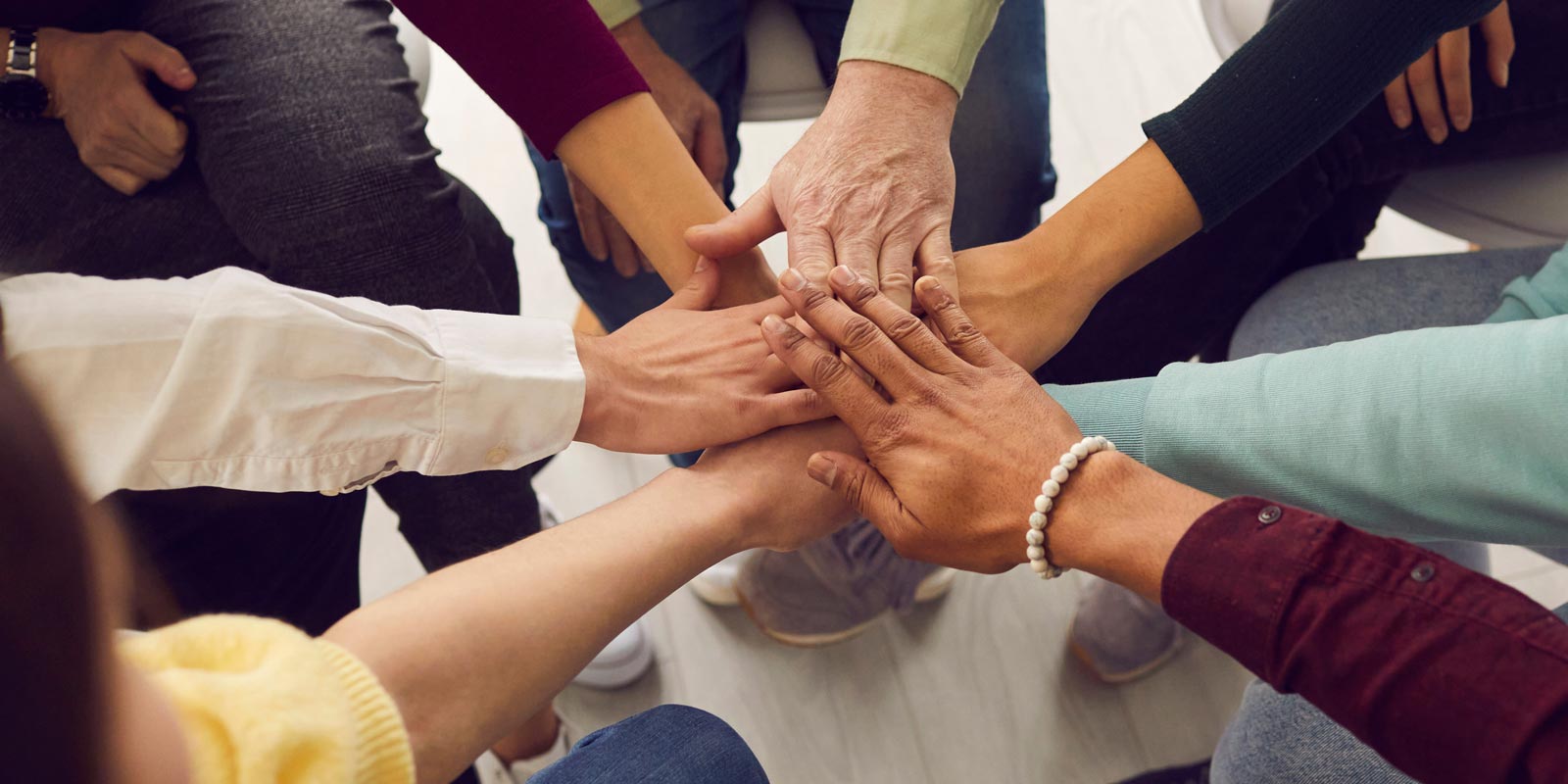 Stack of hands symbolizing teamwork and unity.