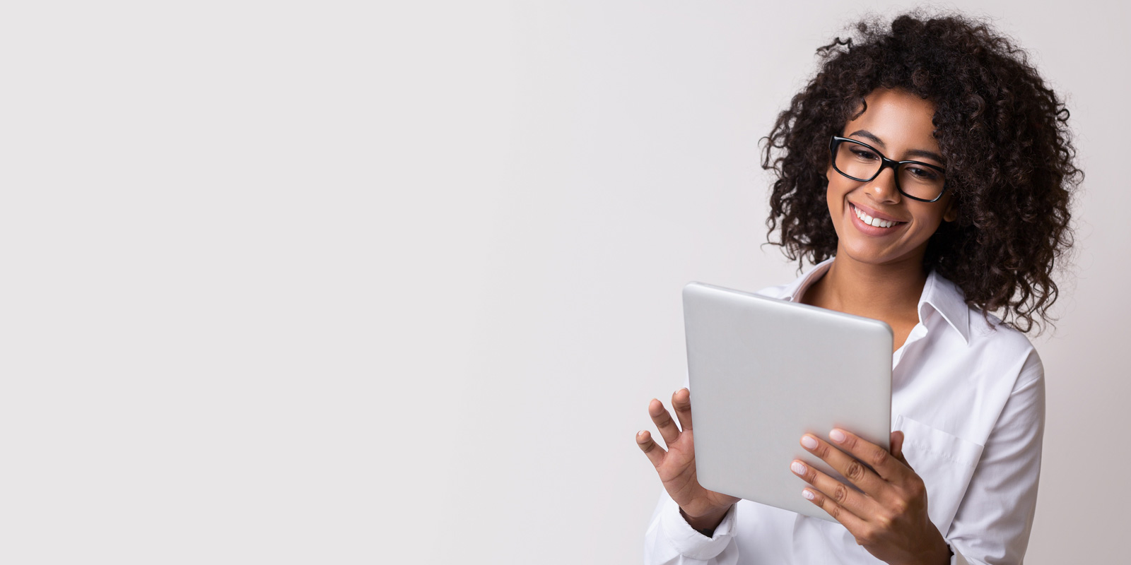 Young woman smiling and holding a tablet.
