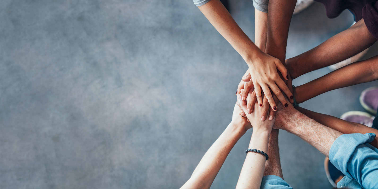 Stack of hands symbolizing teamwork and unity.